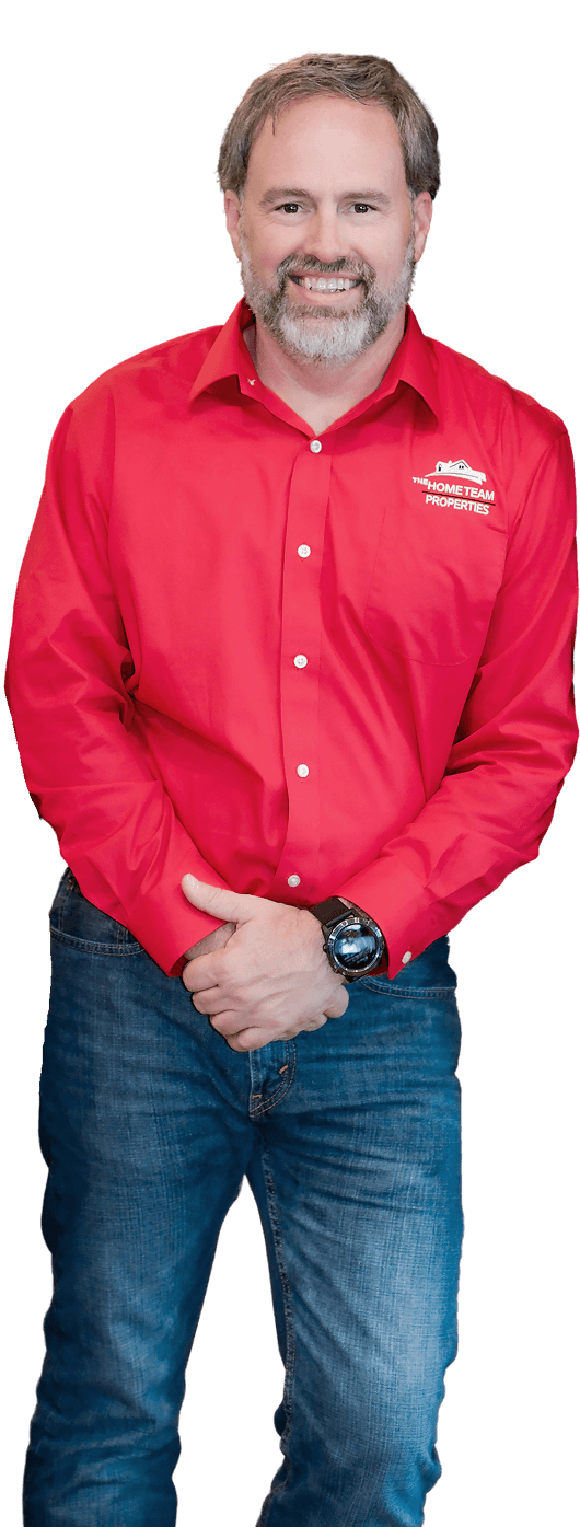 Rob Ranard leaning casually with arms crossed, cut out on a transparent background.
