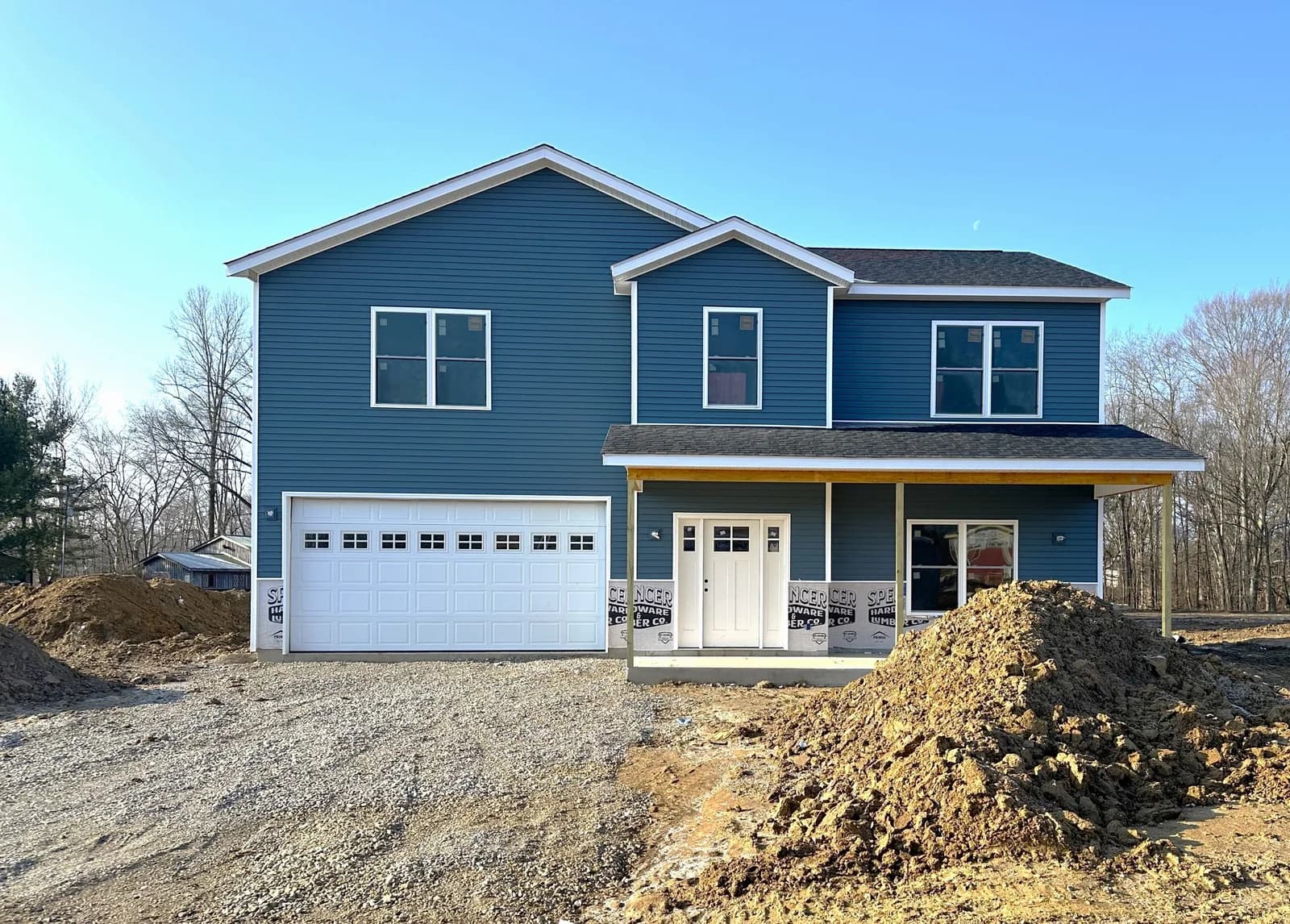 A newly built blue two-story home at Four Oaks with a white two-car garage and covered front porch.