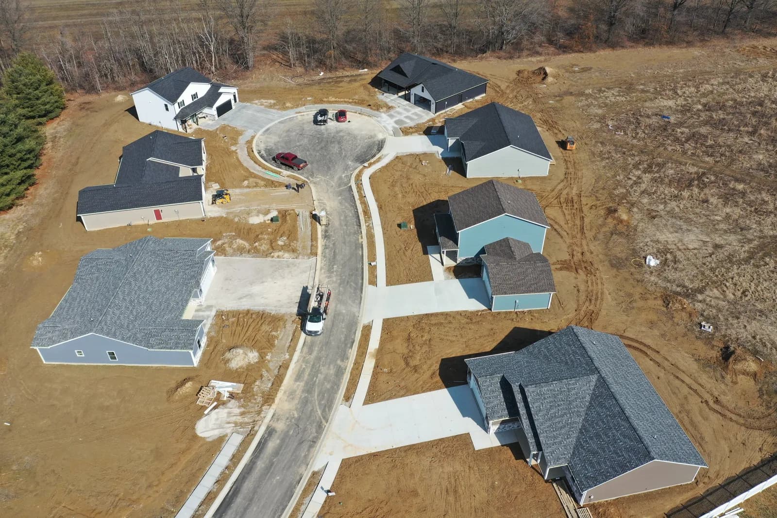 Top-down drone aerial of a Four Oaks cul-de-sac ringed by newly built homes.