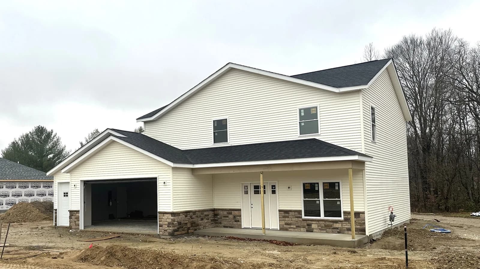 A newly built white two-story home at Four Oaks with a black-shingled roof and attached garage.