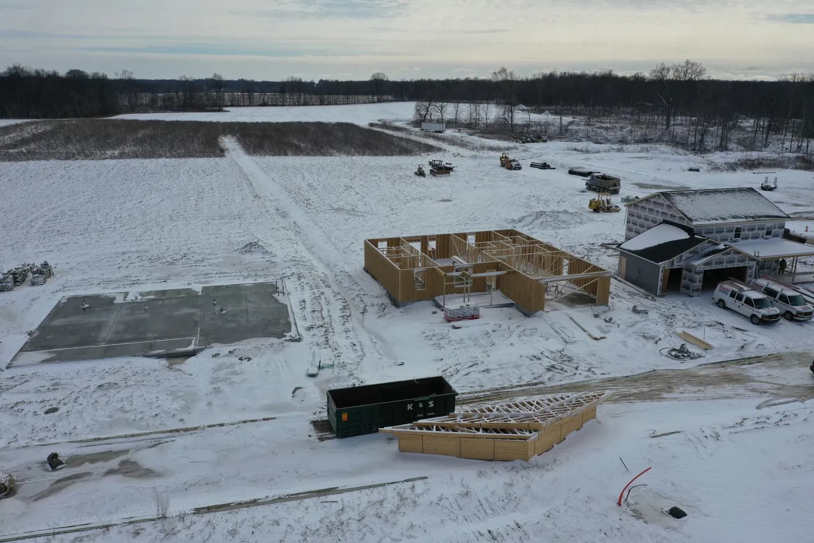 Winter drone aerial of a Four Oaks home being framed in the snow.