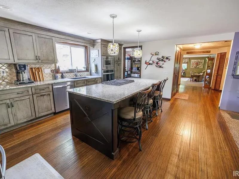 Kitchen with custom cabinetry, granite countertops, and a large island with seating.